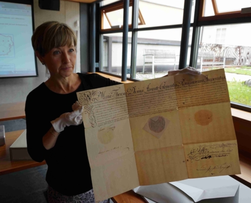 Die Archivarin zeigt eine Urkunde mit Unterschrift von Maria Theresia.